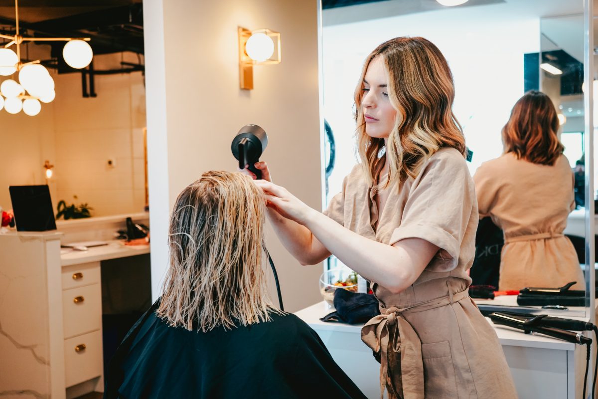 Cosmetologist blow drying hair