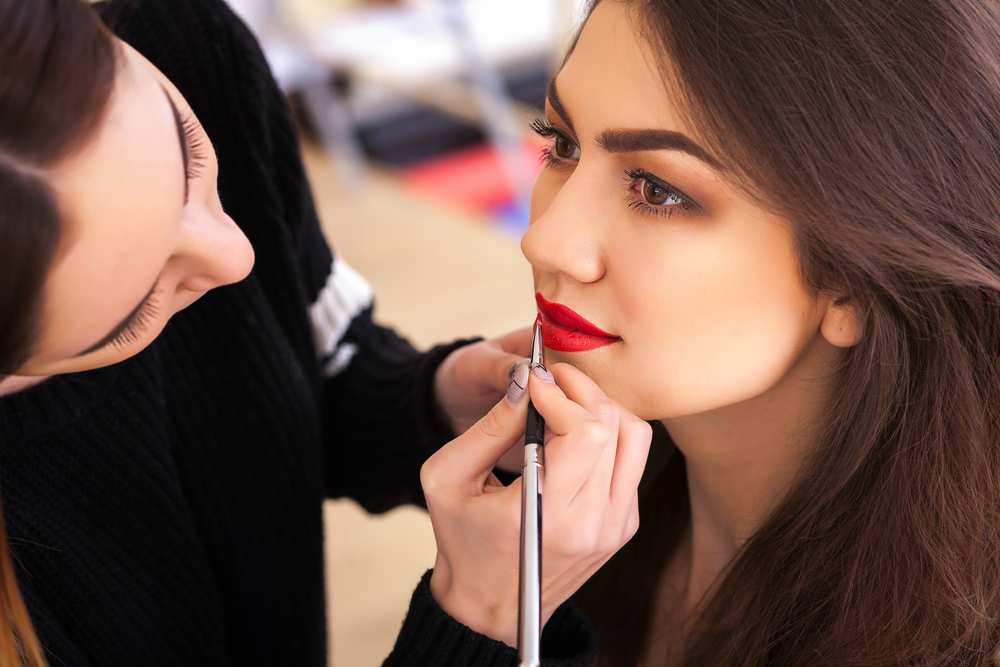 Woman getting lipstick applied